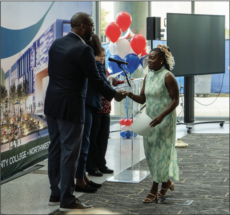 NW Campus Vice President of Student Affair James Edwards presents a naturalization certificate to Shaline Williams who started her citizenship process in 2018.